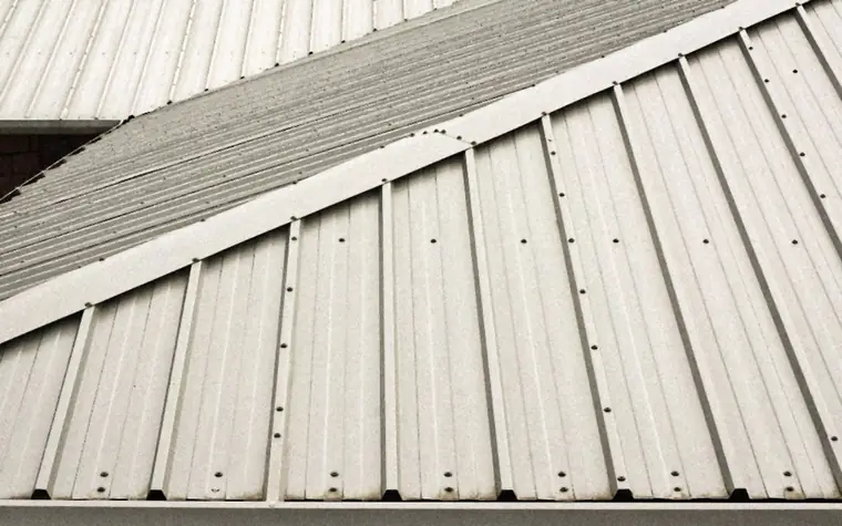 Close-up of metal roof panels with their fastener rows running down the slope