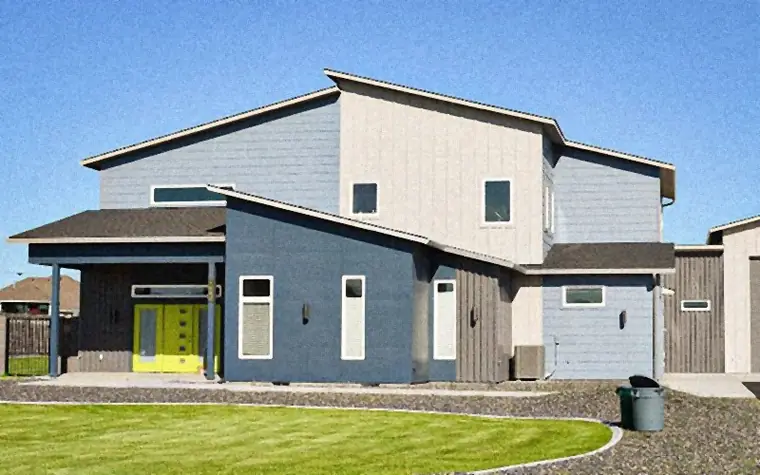A two-storey modern home in navy and cream lap siding with a bright front door